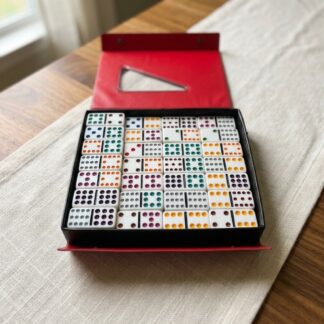 Personalized Mexican Train Double-12 domino set in an open black and red case on a family dining table
